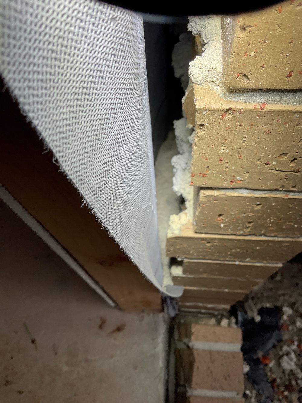 Wall cavity packed with mortar, blocking ventilation and drainage behind the brick, found during a fixing inspection in Strathtulloh