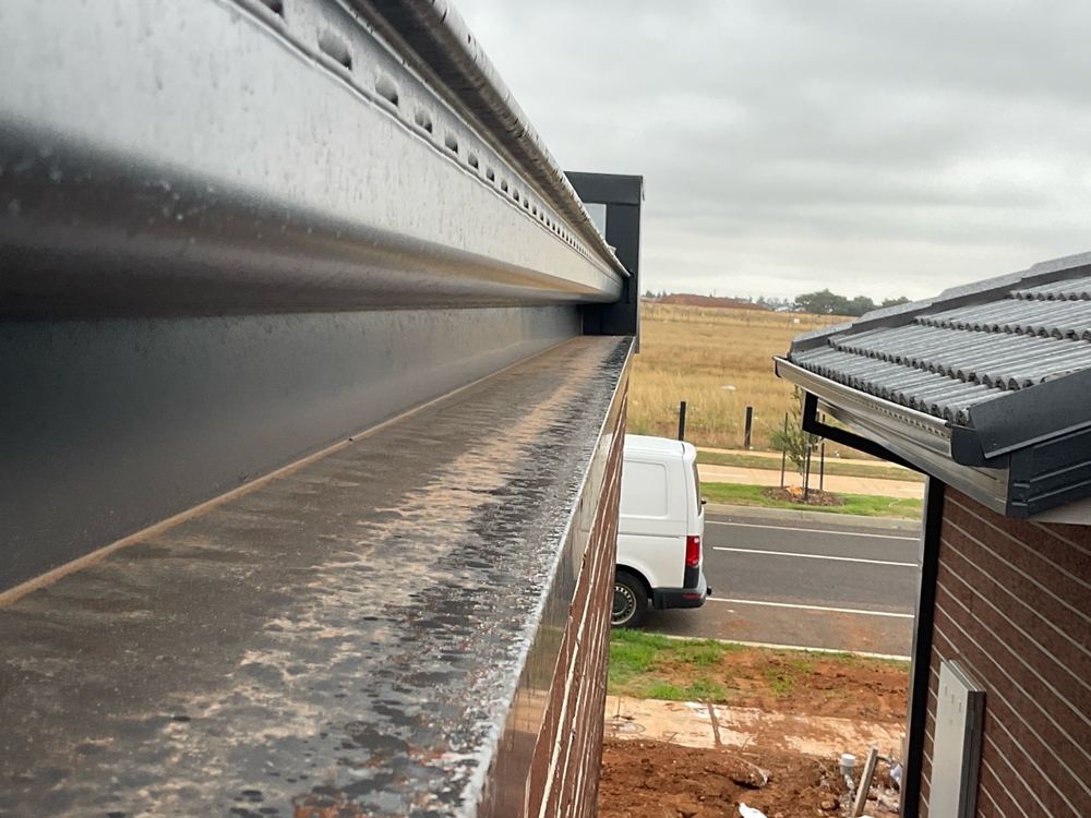 Parapet capping laid flat where it needs a 5 degree fall, found during a pre-handover inspection in Strathtulloh