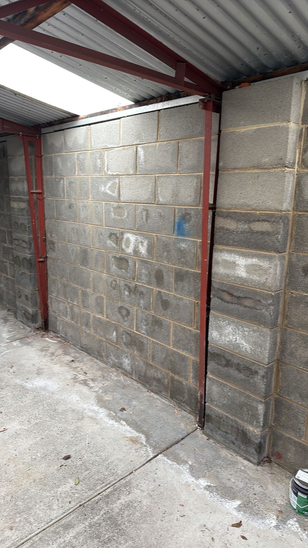 Damp along the garage wall base and slab from past moisture, found during a pre-purchase inspection in Hawthorn