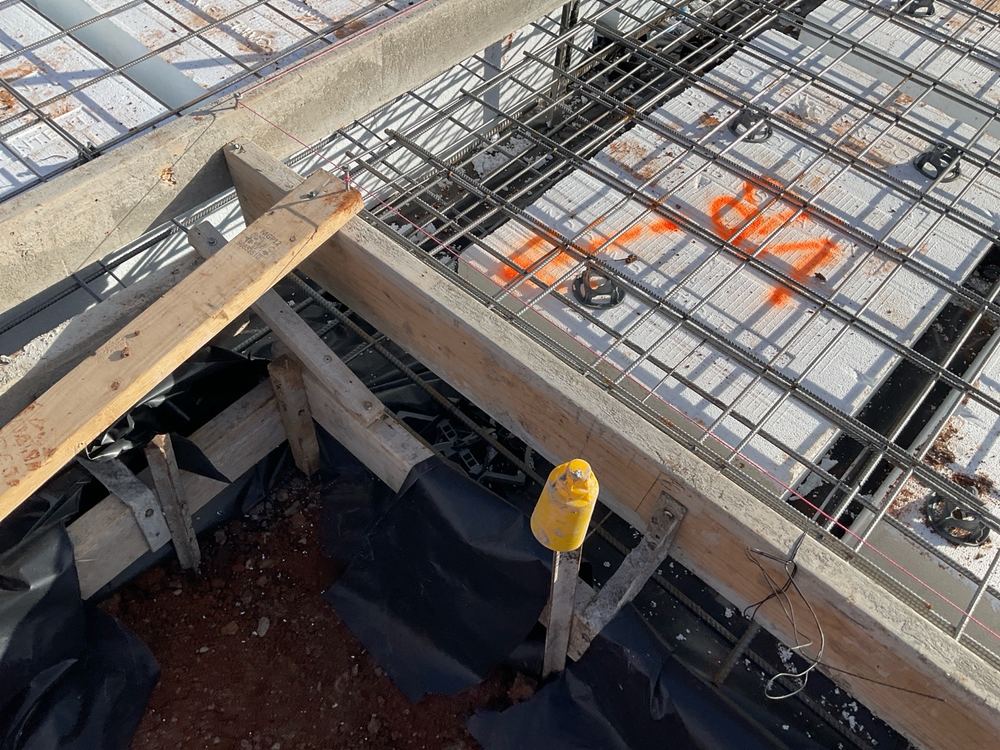 Vapour barrier stopping short of the beam base instead of running to ground, found during a slab pre-pour inspection in Strathtulloh
